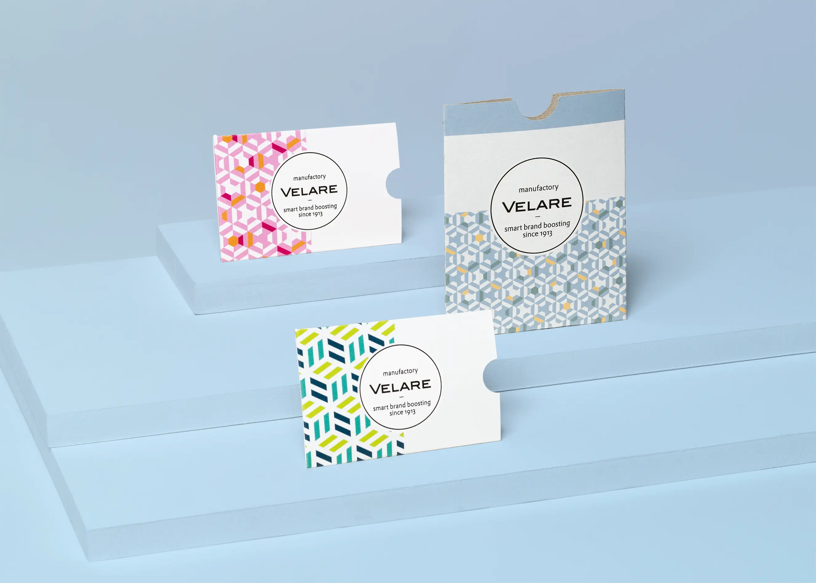 Kartenhülle ohne Verschluss, drei Verpackungen auf dem Podest, in drei unterschiedlichen Größen, blauer Hintergrund